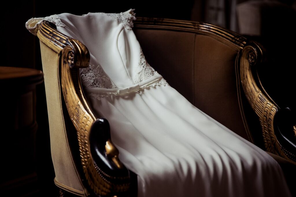 wedding dress elegantly draped across antique chair