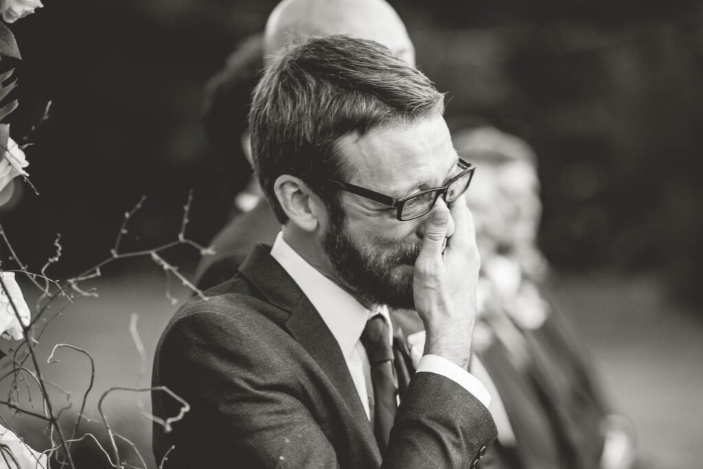 Groom overcome with emotion upon seeing bride walking down aisle.
