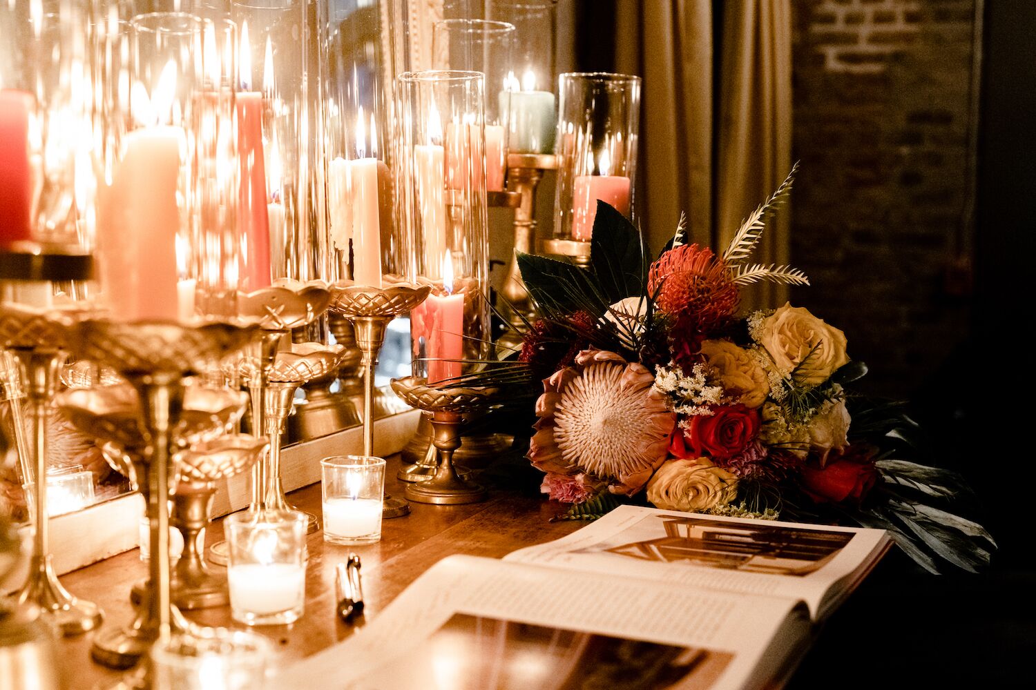 wedding guest book, lit candles, and floral display