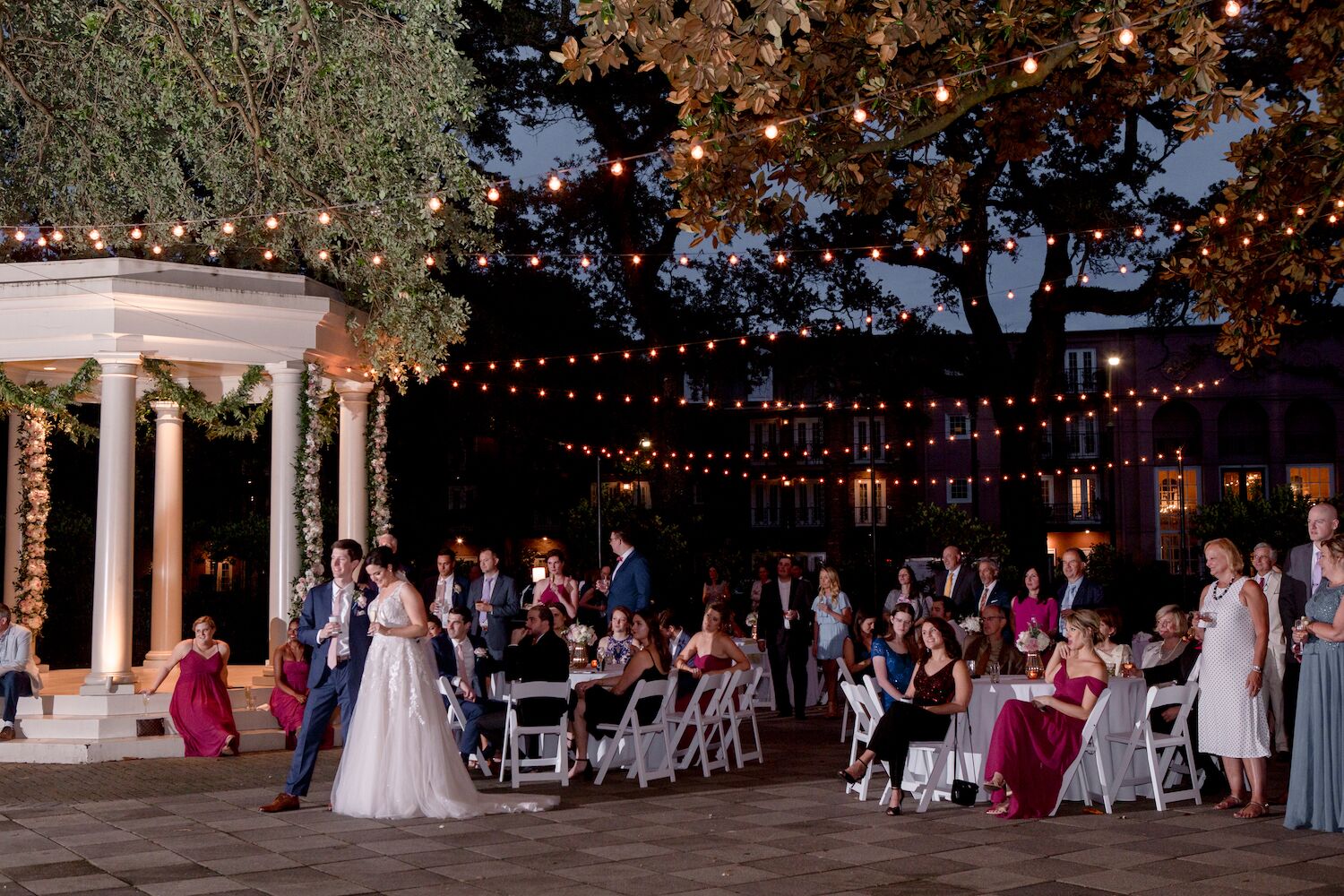 Bride and groom and wedding guests in courtyard