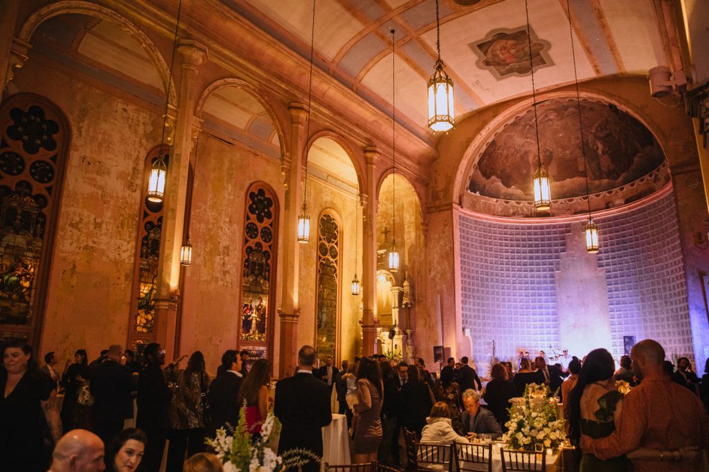 Wedding guests mingle at a nightime reception at the Hotel Peter & Paul.